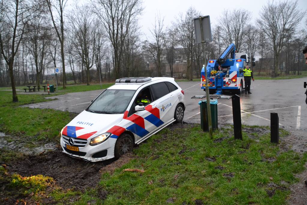Politieauto rijdt zich vast in modder