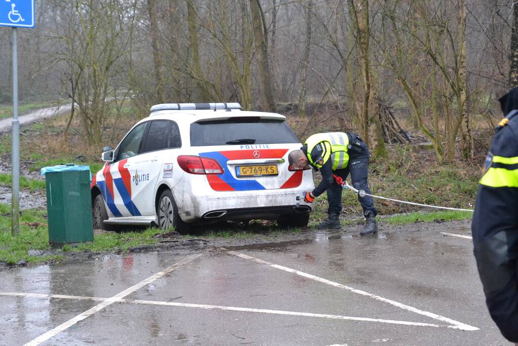 Politieauto rijdt zich vast in modder