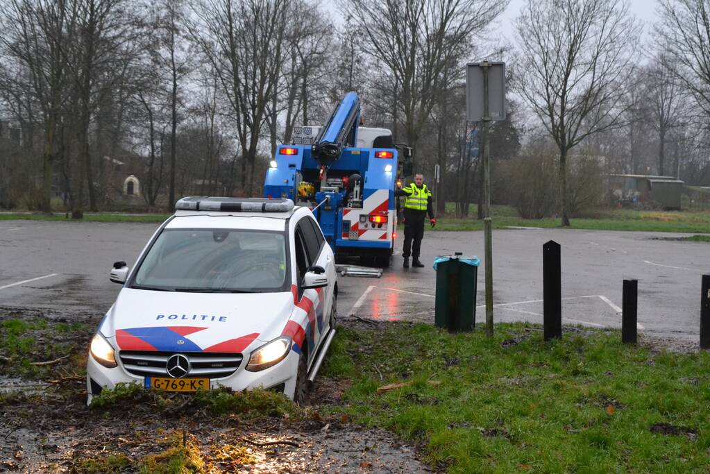 Politieauto rijdt zich vast in modder