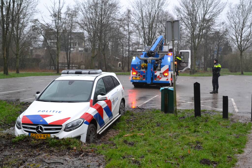 Politieauto rijdt zich vast in modder