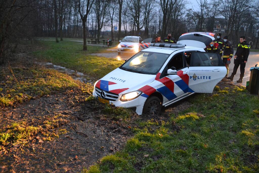 Politieauto rijdt zich vast in modder