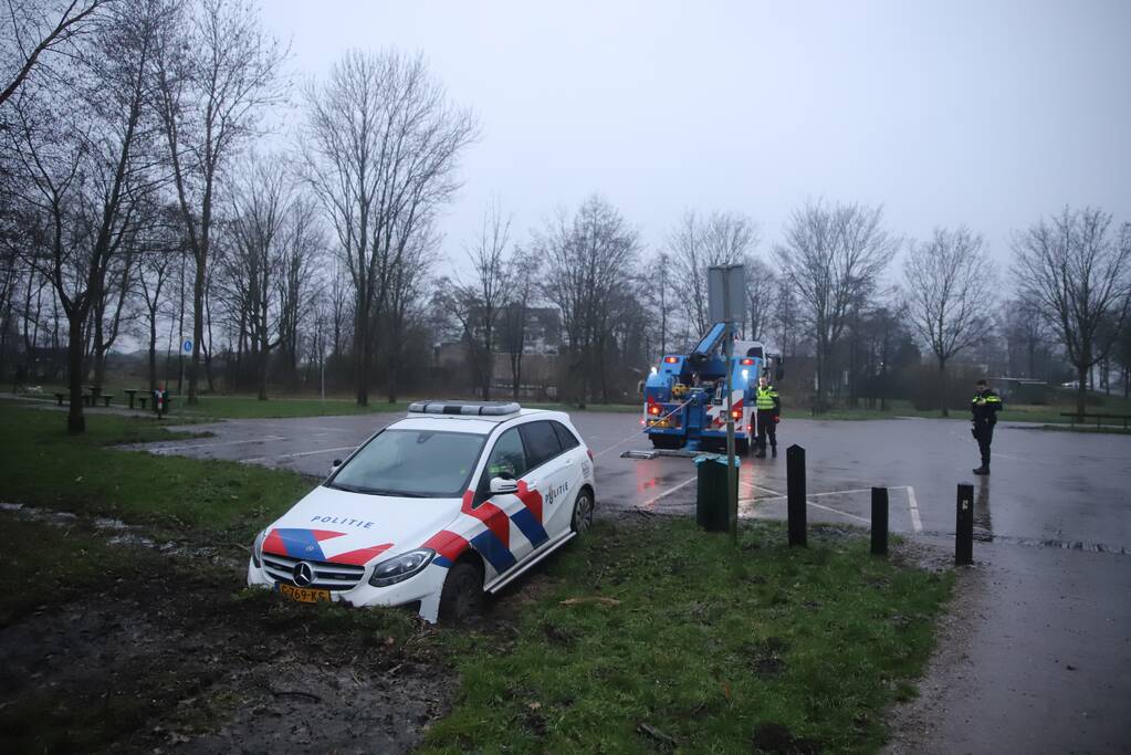 Politieauto rijdt zich vast in modder