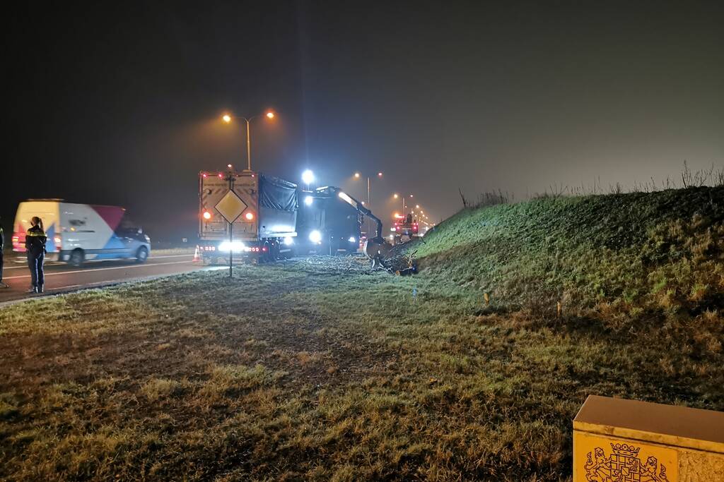 Lading van omgevallen trailer wordt opgeruimd