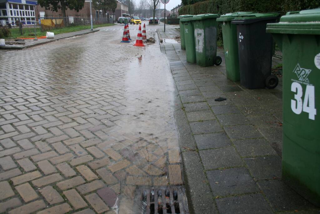 Gat in trottoir door gesprongen waterleiding