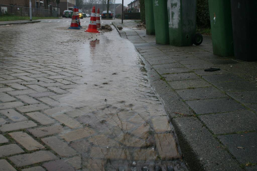 Gat in trottoir door gesprongen waterleiding