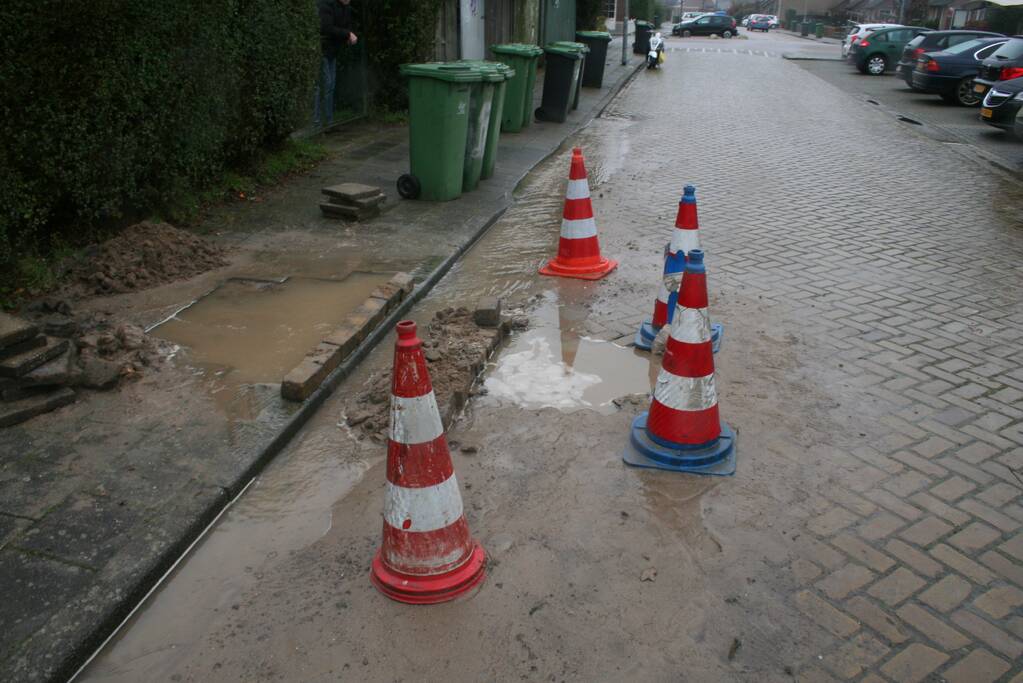 Gat in trottoir door gesprongen waterleiding