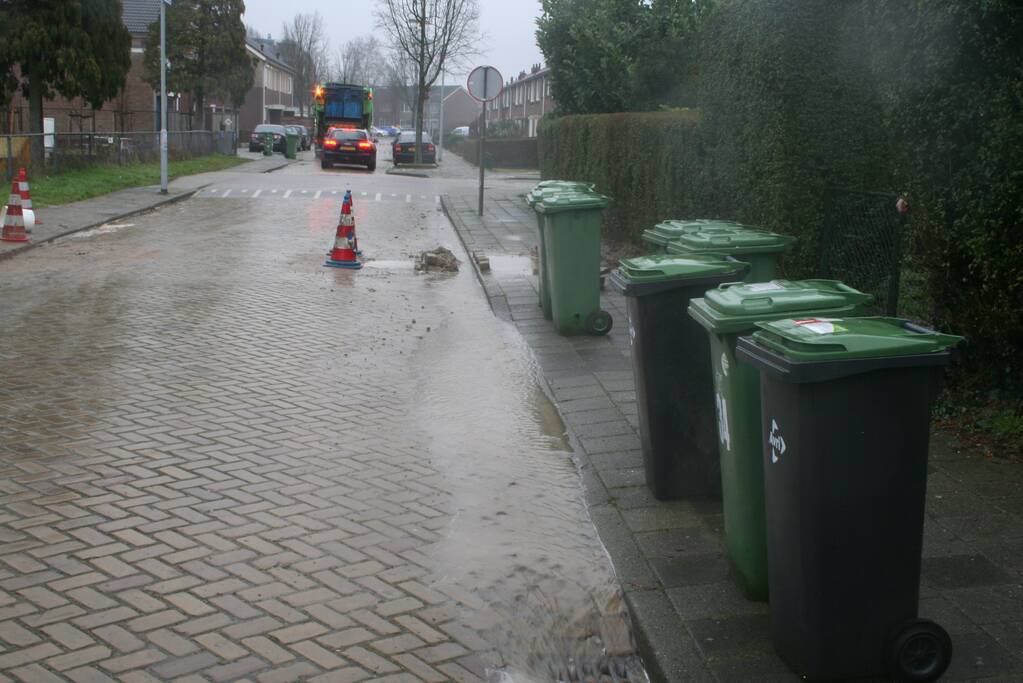 Gat in trottoir door gesprongen waterleiding