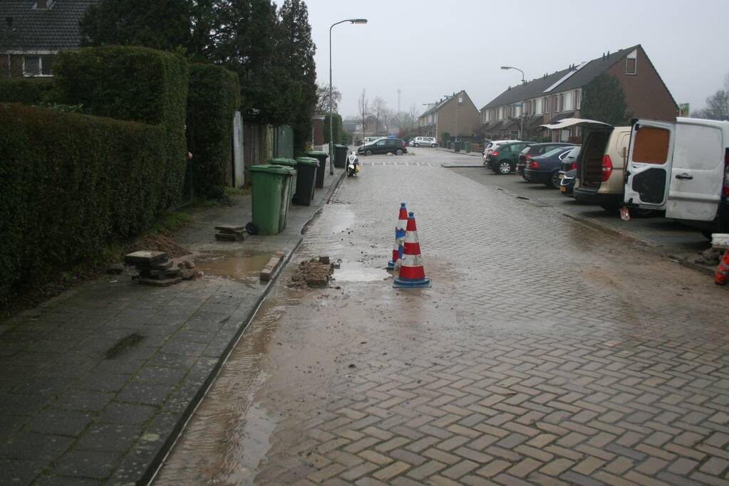 Gat in trottoir door gesprongen waterleiding