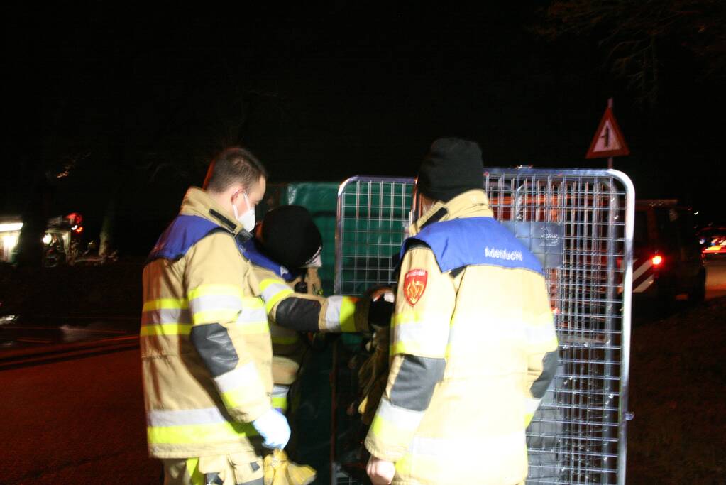 Grote uitslaande brand in loods achter woning