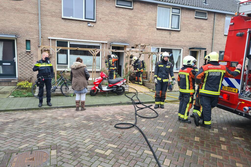 Kleding in woning vliegt in brand