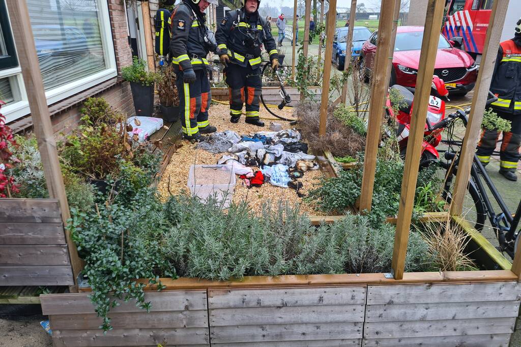 Kleding in woning vliegt in brand