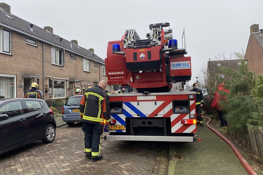 Kleding in woning vliegt in brand