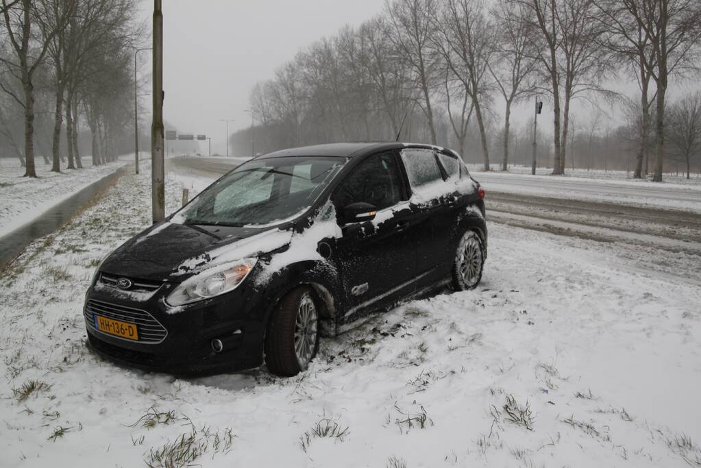 Auto naast de weg en vast in sneeuw