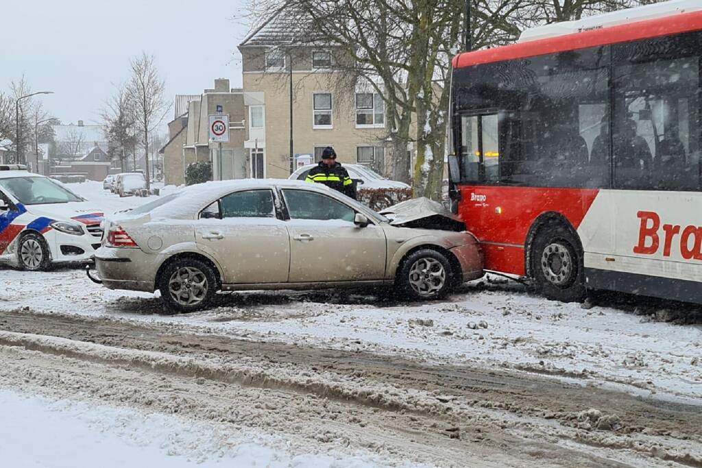 Auto glijdt door gladheid tegen lijnbus