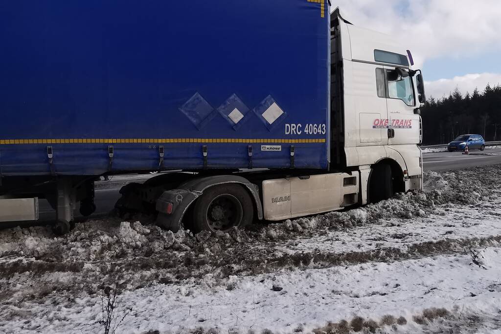 Vrachtwagen met oplegger vast in berm