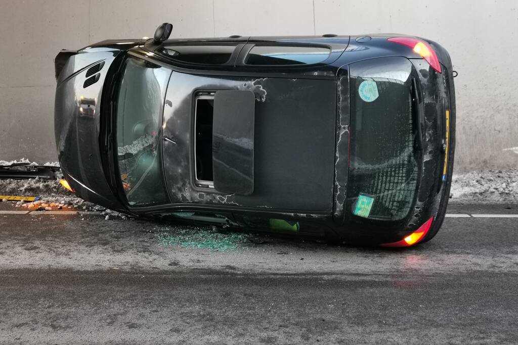 Auto belandt op zijn kant in tunnel