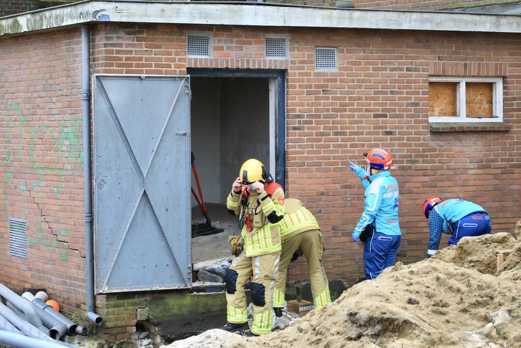 Persoon bekneld onder betonnen plaat