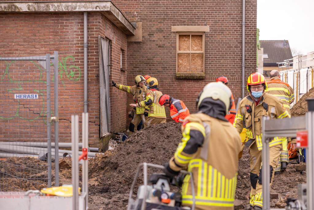Persoon bekneld onder betonnen plaat
