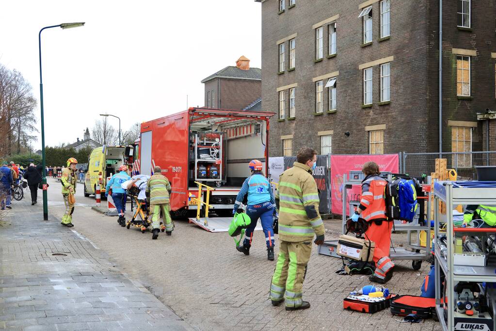 Persoon bekneld onder betonnen plaat