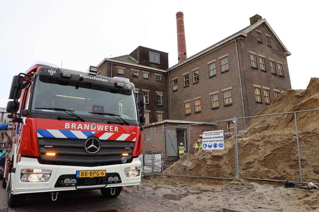 Persoon bekneld onder betonnen plaat