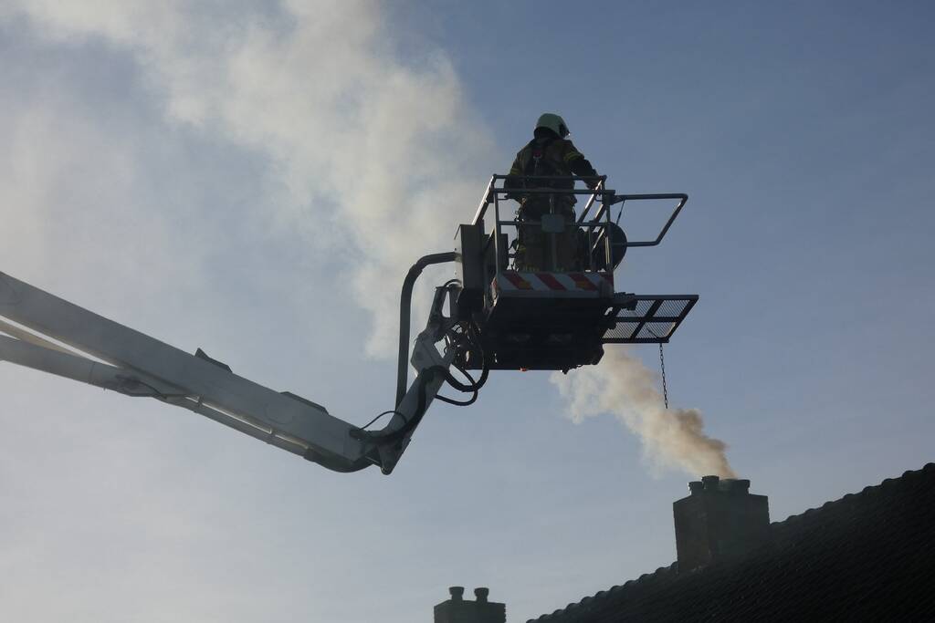 Brandweer veegt schoorsteen na brand