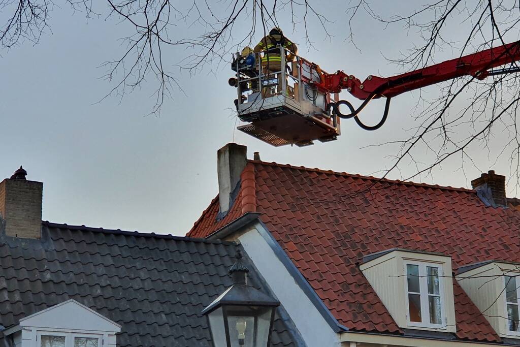 Brandweer veegt schoorsteen na brand