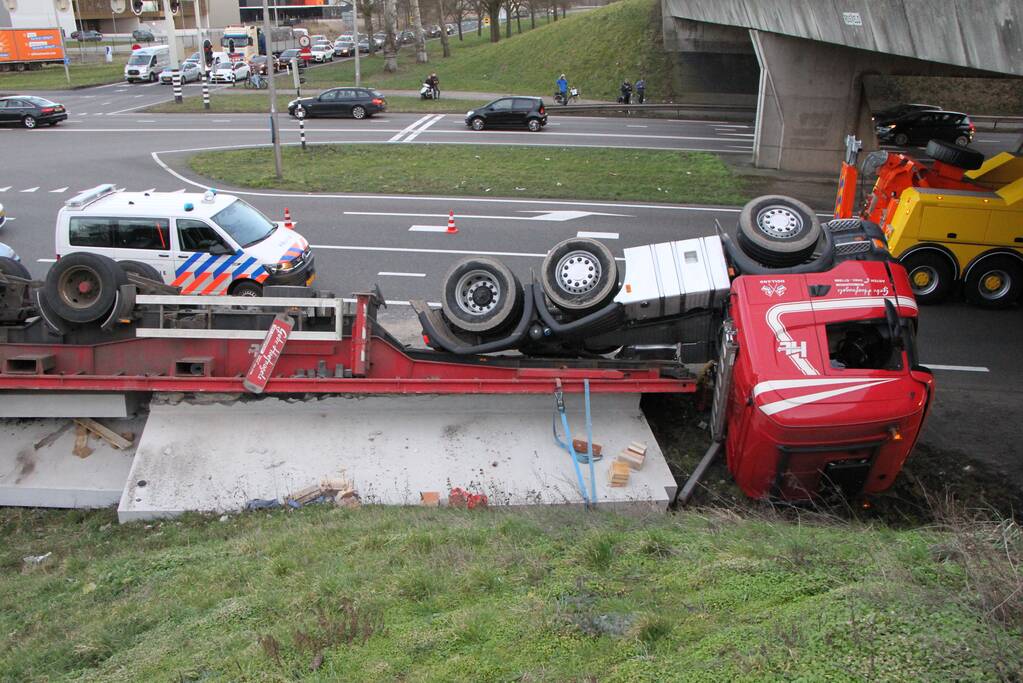 Vrachtwagen met betonplaten belandt op de kop