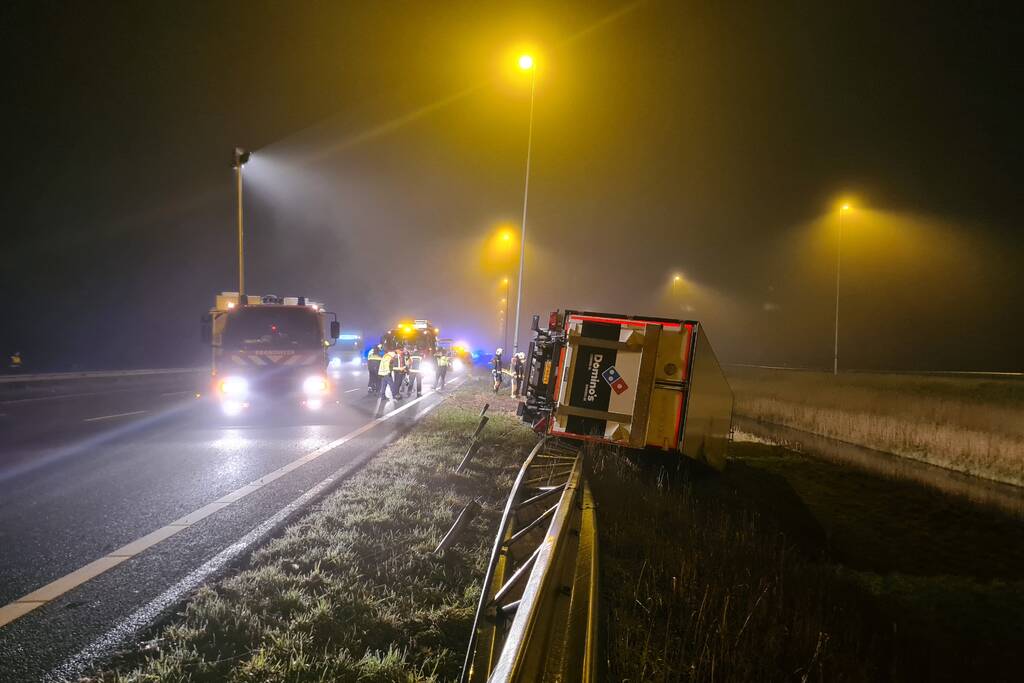 Vrachtwagen belandt op zijn kant in middenberm