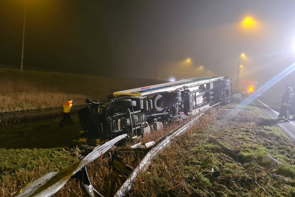 Vrachtwagen belandt op zijn kant in middenberm