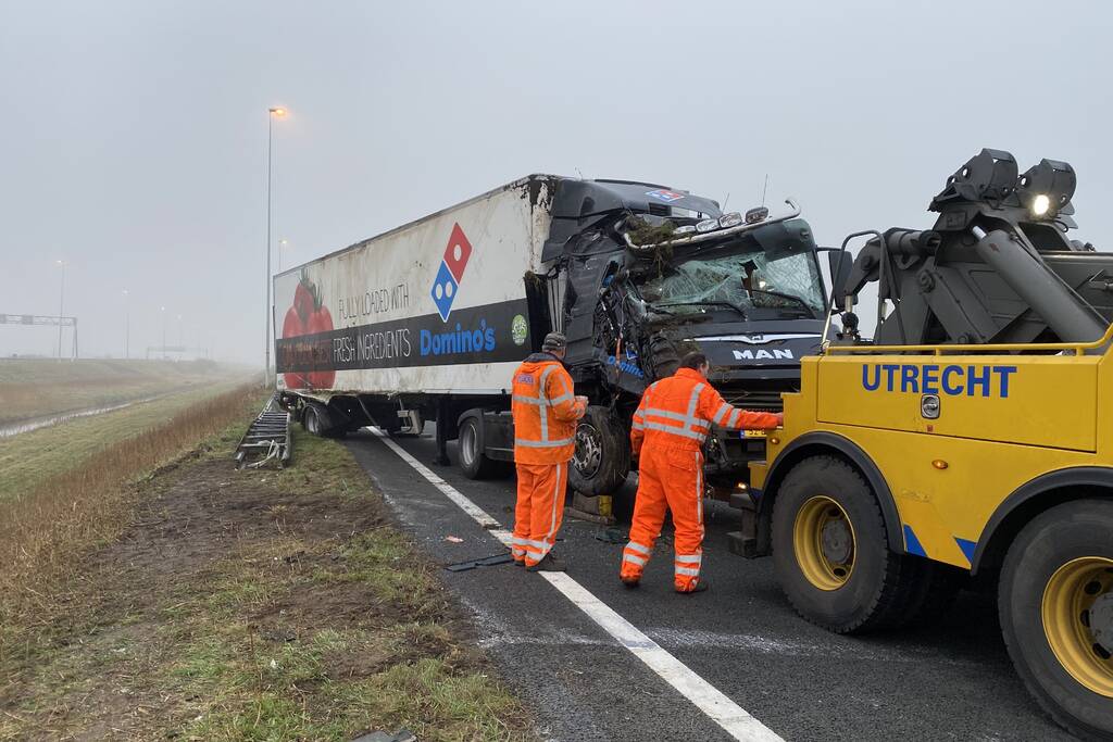 Vrachtwagen belandt op zijn kant in middenberm