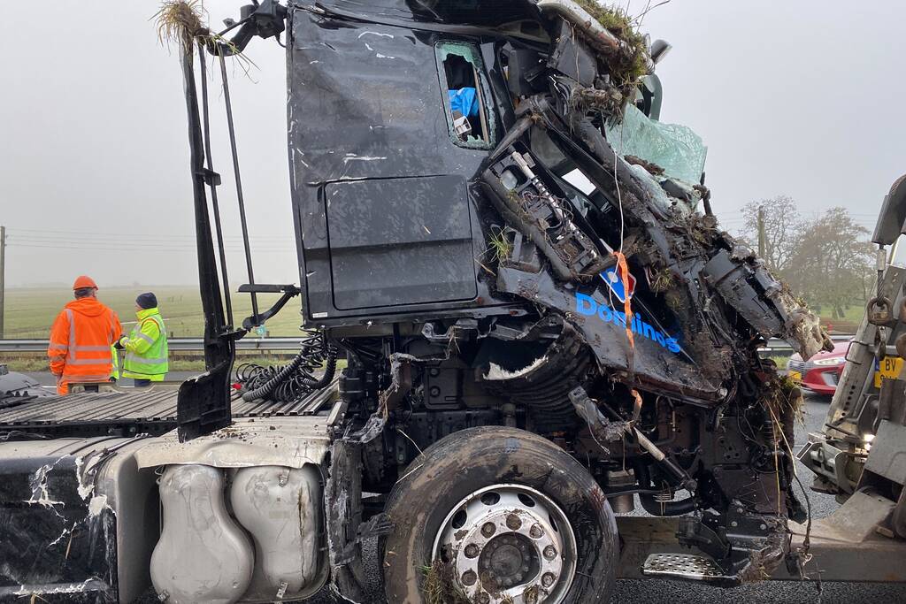 Vrachtwagen belandt op zijn kant in middenberm