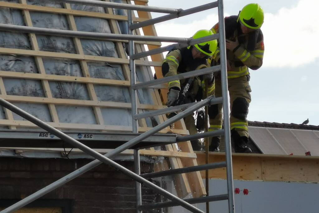 Brandweer blust brandende dakbedekking