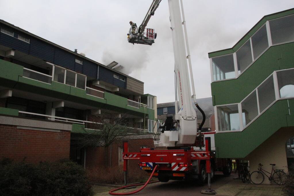 Brandweer blust brandend dak