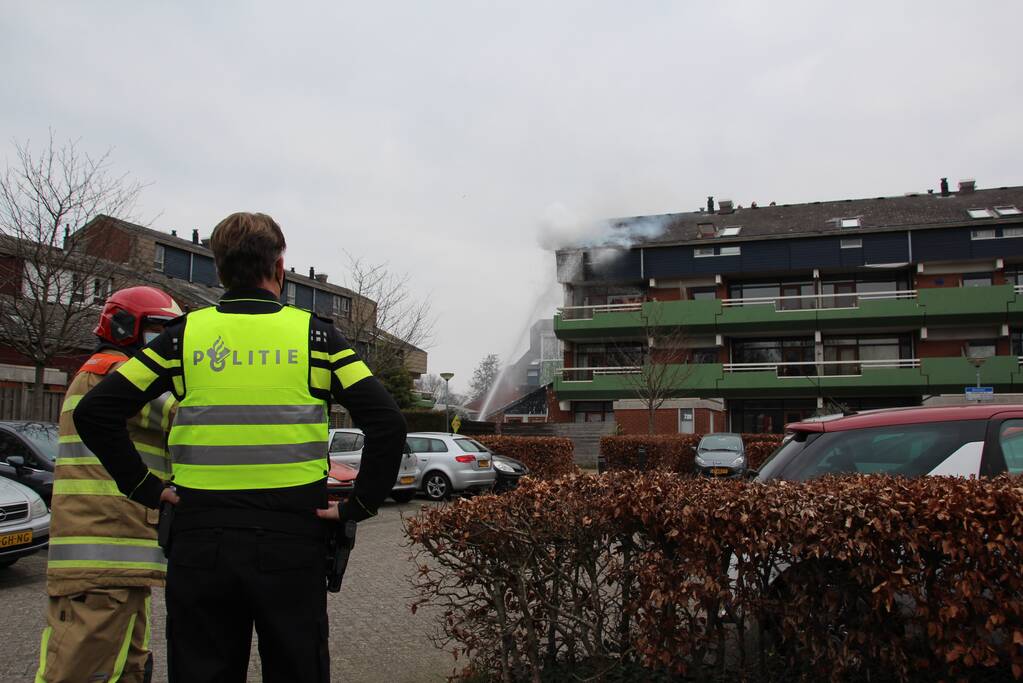 Brandweer blust brandend dak