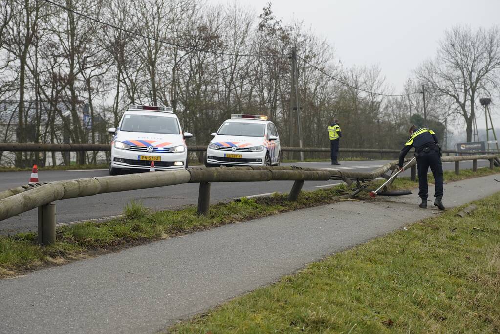 Houten geleiderail aan diggelen bij verkeersongeval