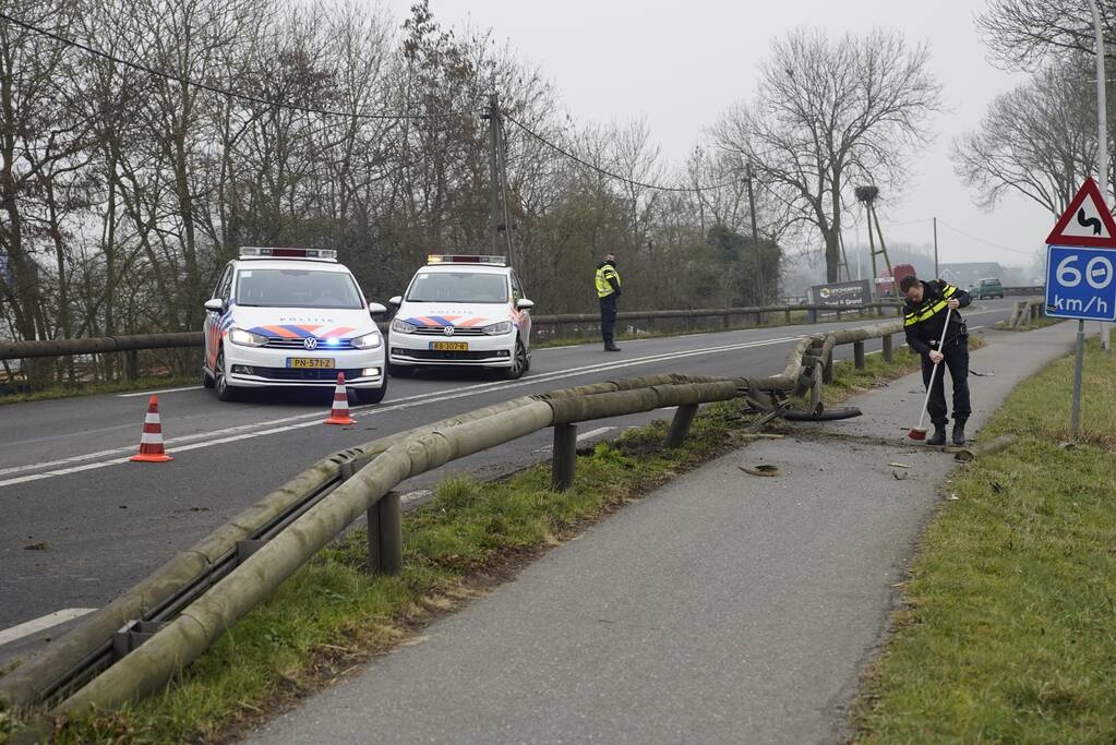 Houten geleiderail aan diggelen bij verkeersongeval