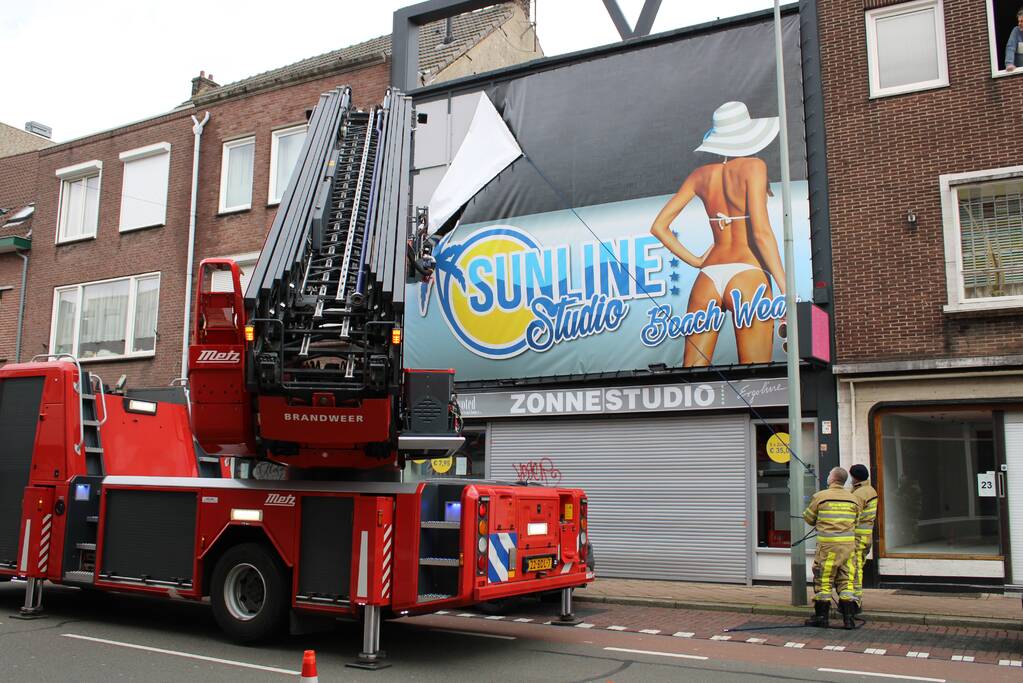 Reclamedoek Zonnestudio losgewaaid