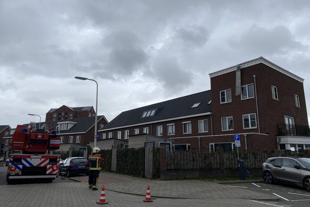 Brandweer haalt losgewaaide platen van dak