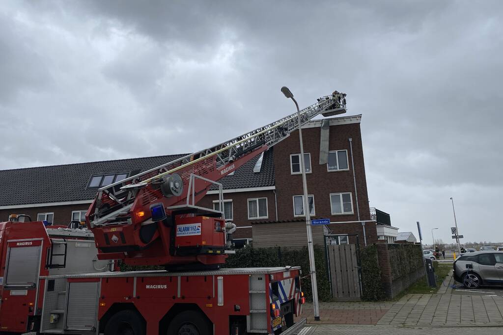 Brandweer haalt losgewaaide platen van dak