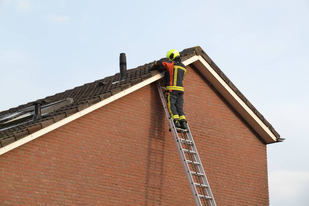 Brandweer legt losliggende dakpannen goed