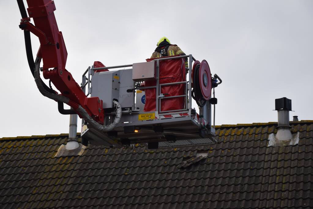 Brandweer legt losliggende dakpannen terug