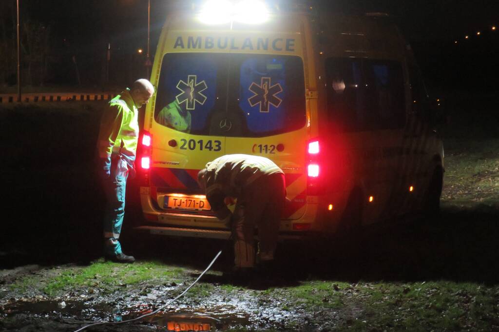 Ambulance vast in grasveld