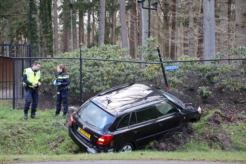 Auto eindigt aan overkant van de weg in hekwerk
