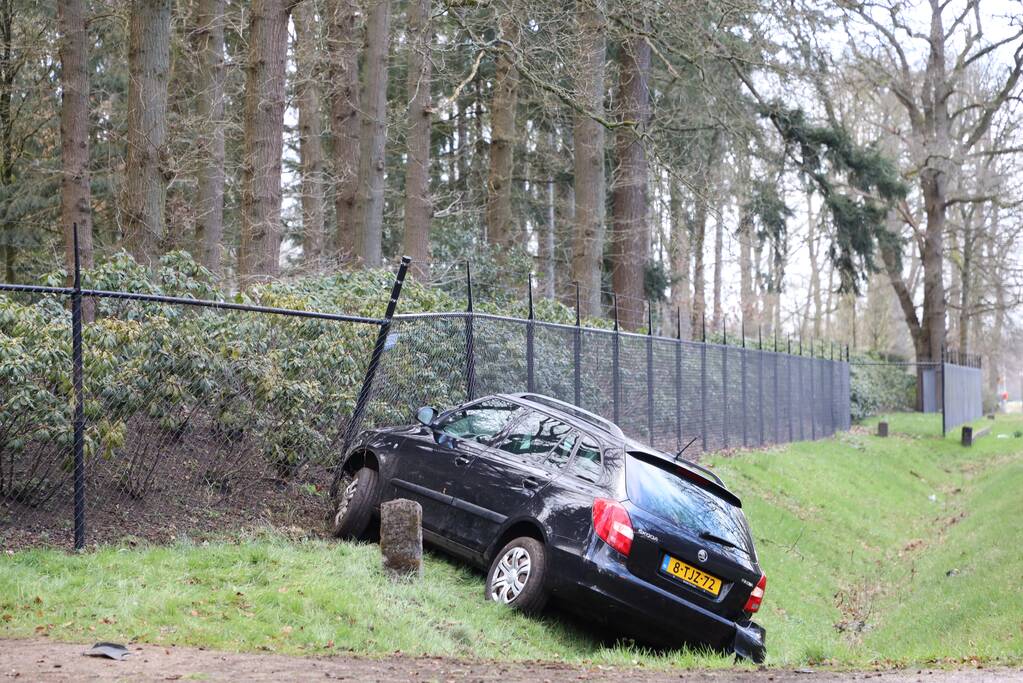 Auto eindigt aan overkant van de weg in hekwerk