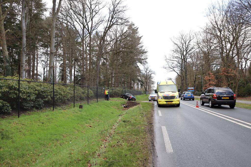 Auto eindigt aan overkant van de weg in hekwerk