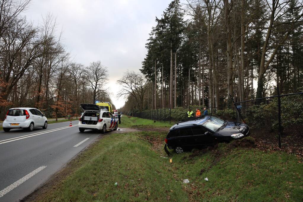 Auto eindigt aan overkant van de weg in hekwerk