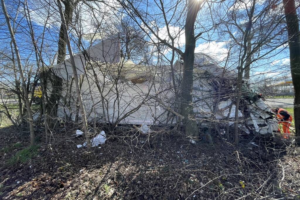 Vrachtwagen belandt in berm tegen boom