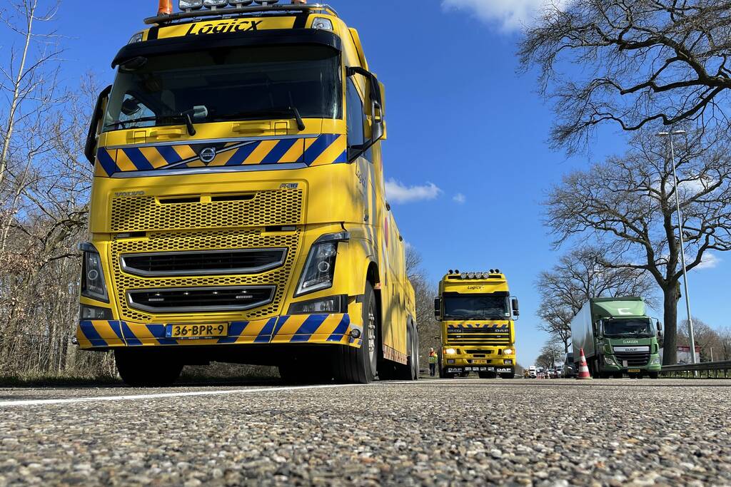 Vrachtwagen belandt in berm tegen boom