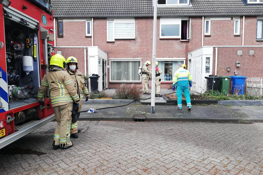 Zwarte rook uit woning door brand in slaapkamer