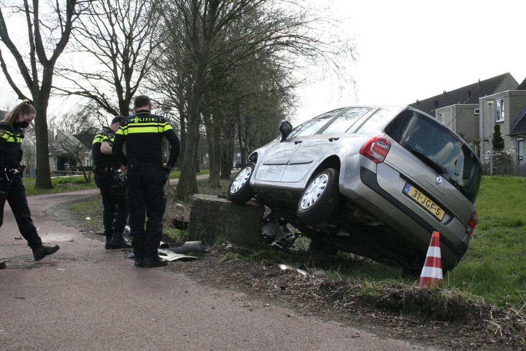 Auto botst op betonblok met lantaarnpaal